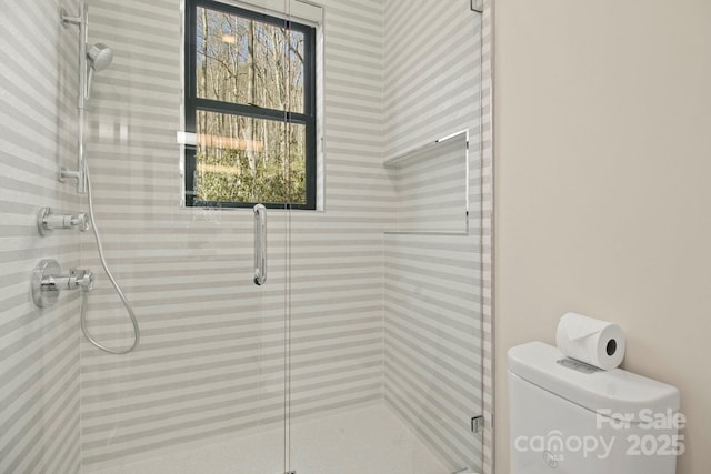 bathroom with an enclosed shower, plenty of natural light, and toilet