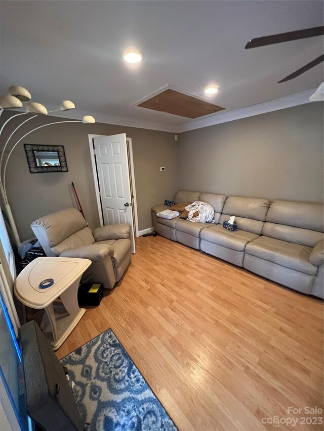 living room with light hardwood / wood-style floors, ceiling fan, and crown molding