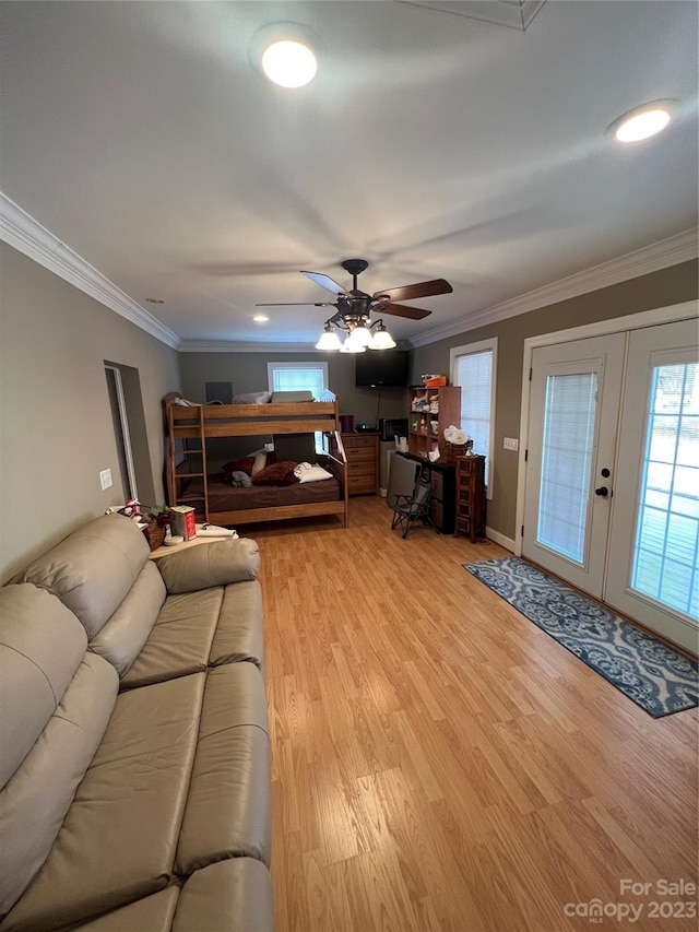 living room with ornamental molding, light hardwood / wood-style floors, ceiling fan, and french doors