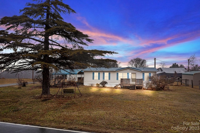 view of front of house featuring a lawn and a wooden deck