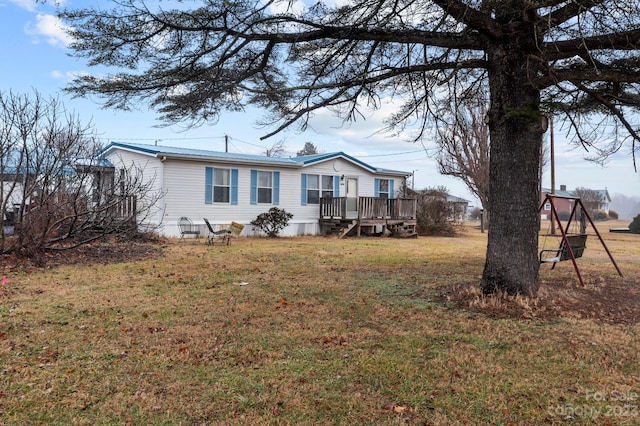 rear view of house with a wooden deck and a lawn