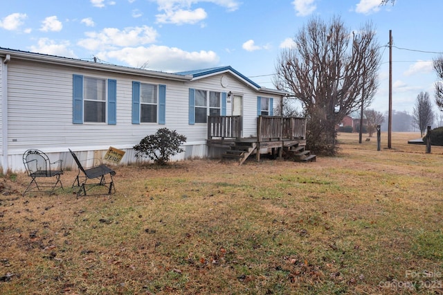 rear view of house with a yard and a wooden deck