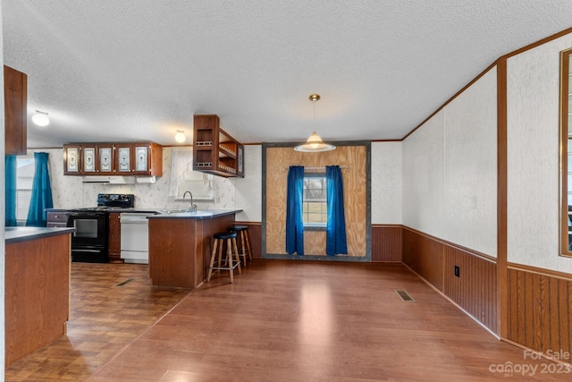 kitchen with kitchen peninsula, dark wood-type flooring, black electric range, and a textured ceiling