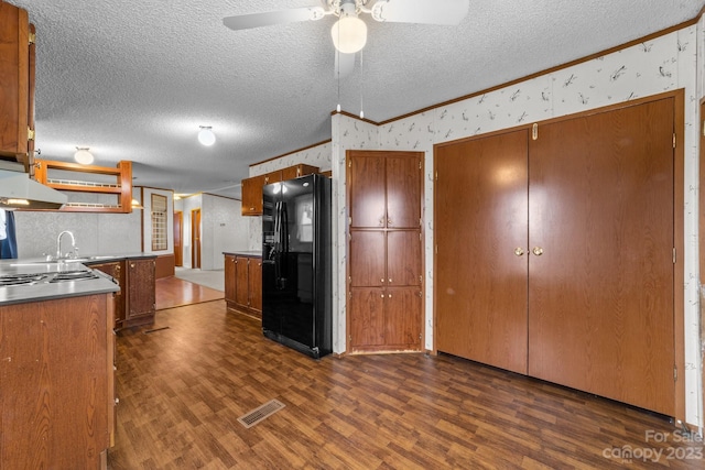 kitchen with black refrigerator with ice dispenser, a textured ceiling, dark wood-type flooring, and ventilation hood