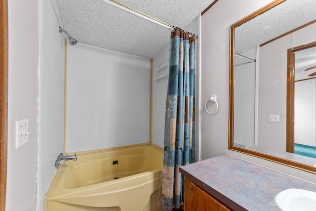 bathroom featuring shower / tub combo, a textured ceiling, ceiling fan, and vanity with extensive cabinet space