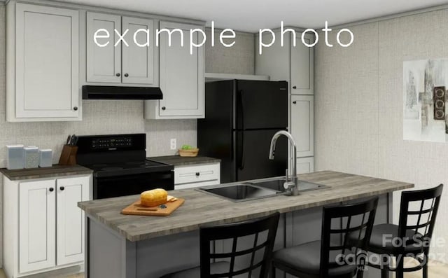 kitchen featuring sink, white cabinetry, black appliances, and a breakfast bar area