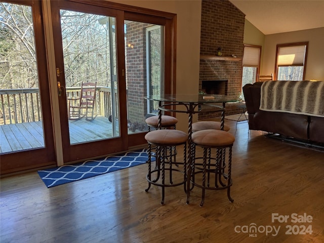 dining area featuring wood-type flooring, vaulted ceiling, and a wealth of natural light