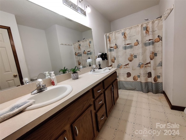 bathroom with tile patterned flooring and dual bowl vanity