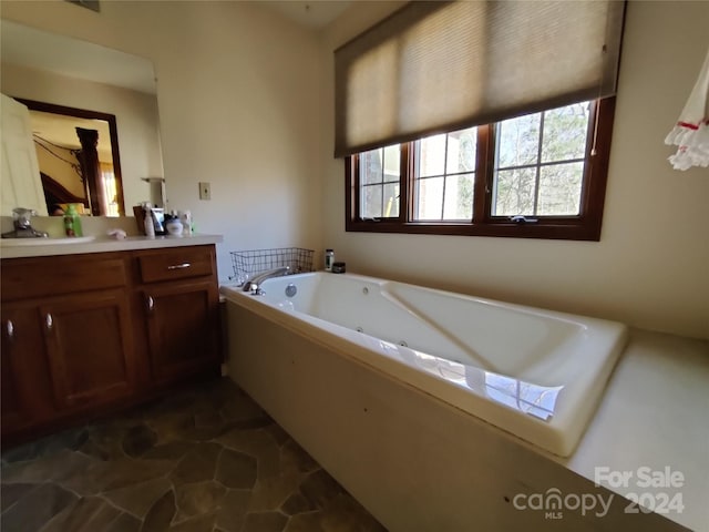 bathroom featuring vanity, tile patterned flooring, and a bathing tub