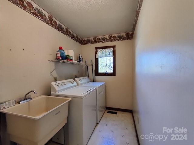 washroom featuring washer and clothes dryer, sink, and light tile patterned floors