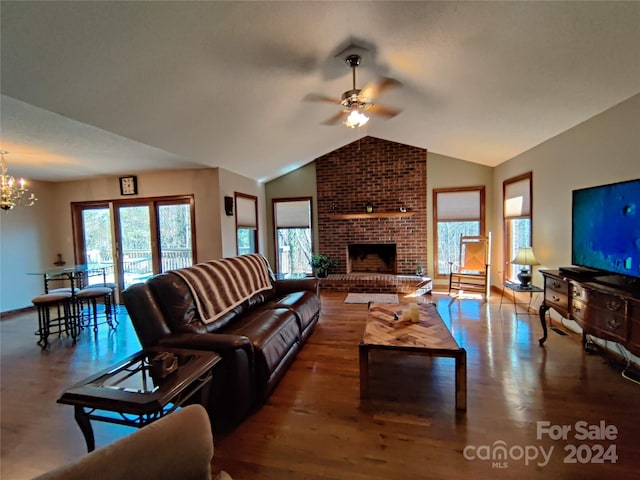 living room featuring ceiling fan with notable chandelier, a fireplace, brick wall, hardwood / wood-style flooring, and vaulted ceiling