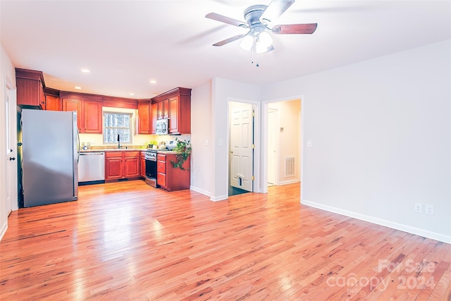 kitchen with appliances with stainless steel finishes, ceiling fan, and light wood-type flooring