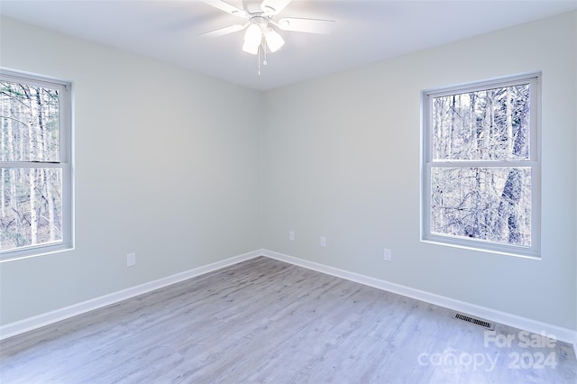 unfurnished room featuring plenty of natural light, ceiling fan, and light hardwood / wood-style floors