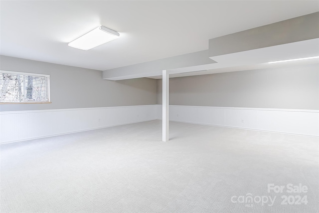 basement featuring light colored carpet