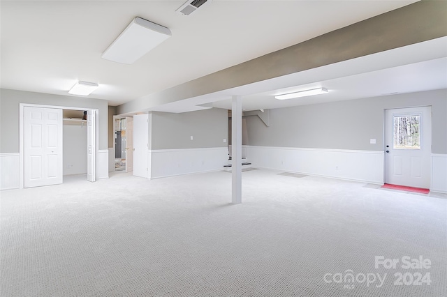 basement featuring light carpet