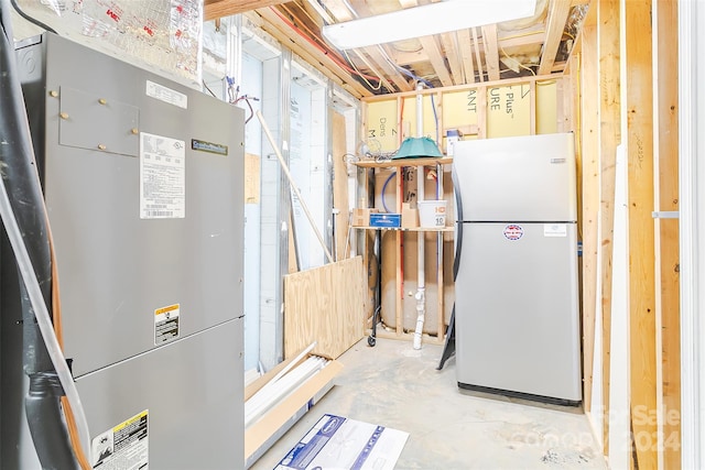 basement featuring heating utilities and white fridge