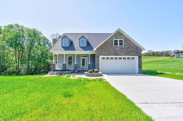 view of front of property featuring a front yard, a porch, and a garage