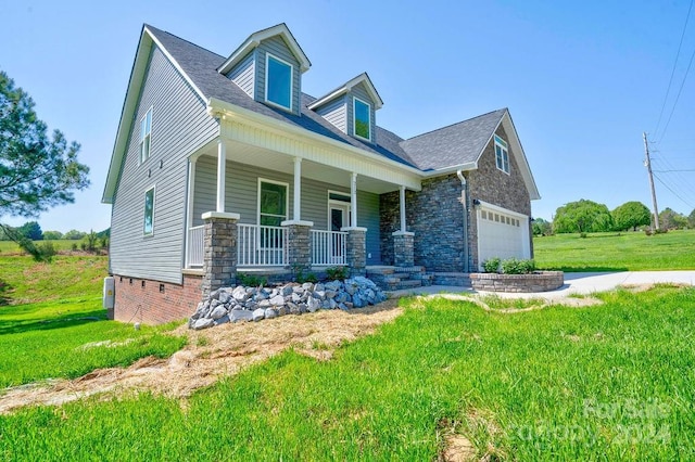 view of front of property featuring a garage, a porch, and a front yard