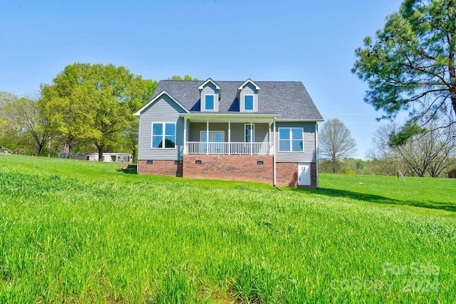 new england style home featuring a front lawn and a porch