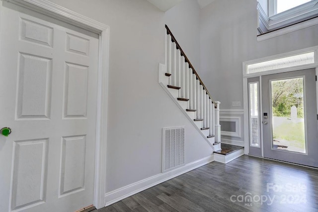 entryway featuring a towering ceiling and dark hardwood / wood-style floors