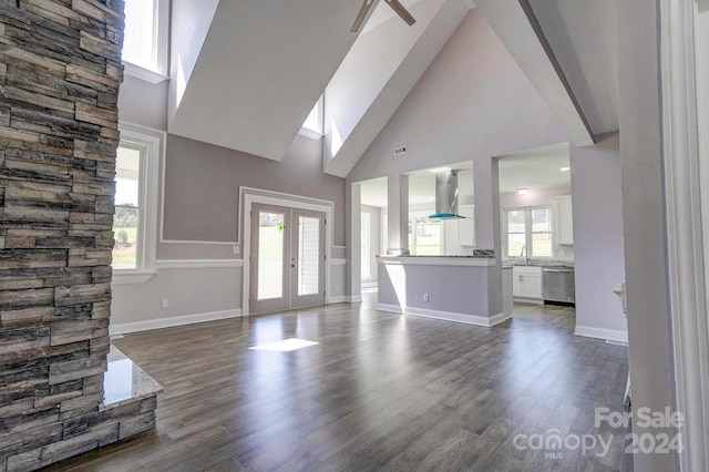 unfurnished living room with french doors, dark wood-type flooring, high vaulted ceiling, and sink