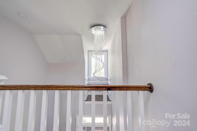 stairway featuring vaulted ceiling and a notable chandelier