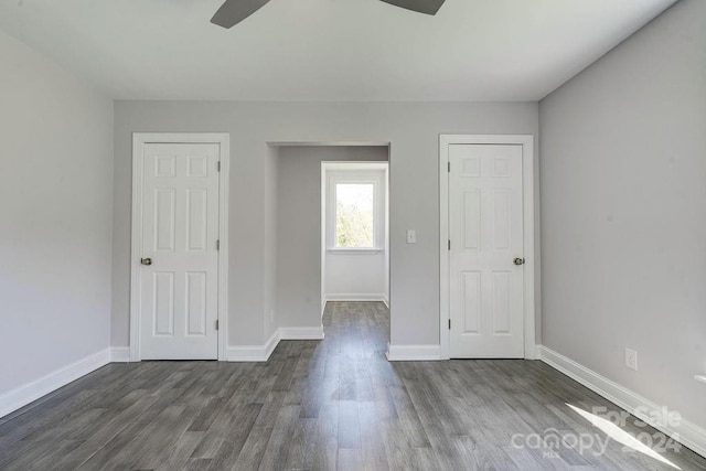 unfurnished room with ceiling fan and dark wood-type flooring