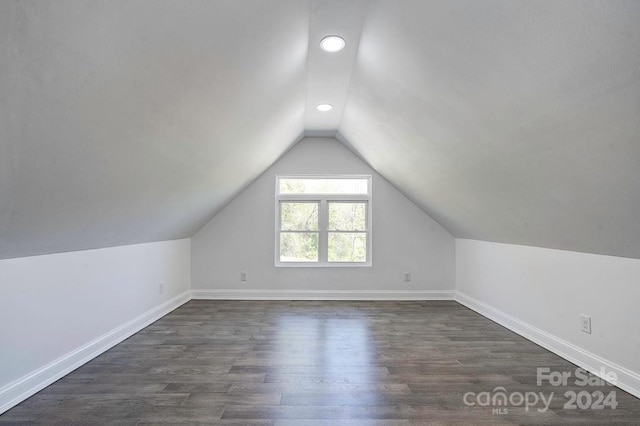 bonus room with dark hardwood / wood-style flooring and vaulted ceiling