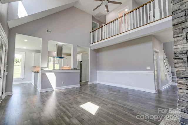 unfurnished living room with high vaulted ceiling, ceiling fan, and dark hardwood / wood-style floors