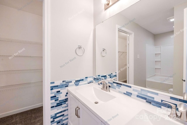 full bathroom with tile walls, backsplash, toilet, and vanity