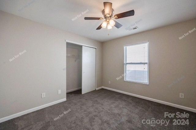 unfurnished bedroom with dark carpet, a closet, and ceiling fan