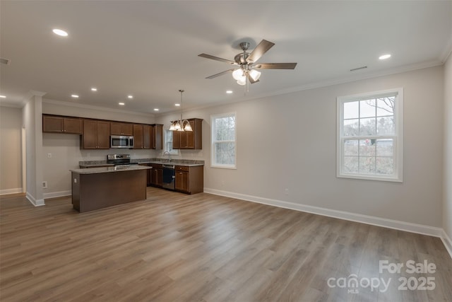 kitchen with ceiling fan with notable chandelier, stainless steel appliances, a center island, light hardwood / wood-style floors, and hanging light fixtures