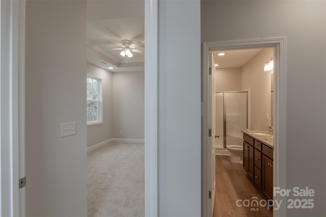 bathroom featuring ceiling fan, hardwood / wood-style floors, toilet, vanity, and a shower with shower door