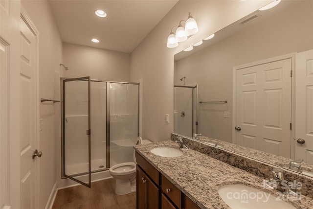 bathroom with hardwood / wood-style floors, vanity, toilet, and an enclosed shower