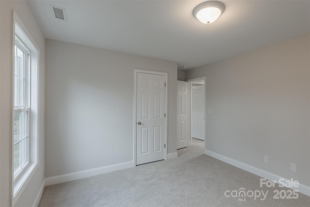 unfurnished bedroom featuring light carpet