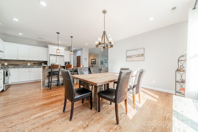 dining area featuring a chandelier and light wood-type flooring