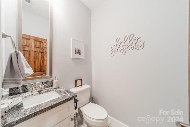 bathroom with tile floors, toilet, and vanity