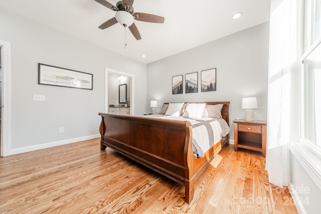 bedroom featuring ensuite bath, light hardwood / wood-style floors, and ceiling fan