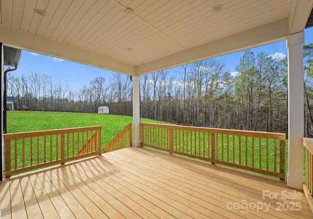 deck featuring a yard and a storage unit