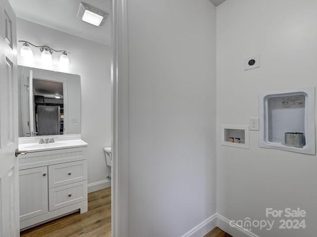 bathroom with hardwood / wood-style flooring, vanity, and toilet