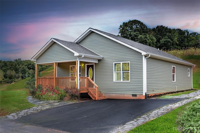 view of front facade featuring covered porch and a yard