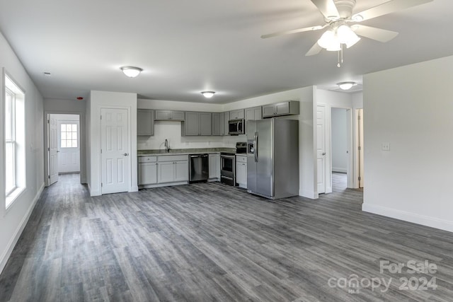 kitchen featuring ceiling fan, dark hardwood / wood-style floors, gray cabinets, sink, and appliances with stainless steel finishes