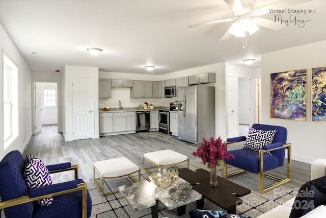 living room with ceiling fan, sink, and light hardwood / wood-style flooring