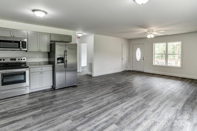 kitchen with ceiling fan, appliances with stainless steel finishes, dark hardwood / wood-style flooring, and gray cabinets