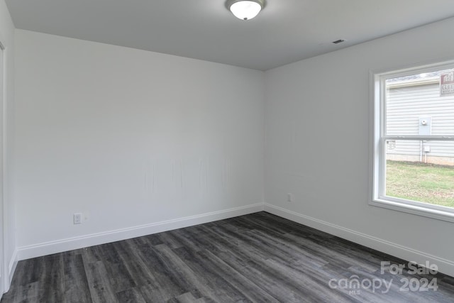 unfurnished room with dark hardwood / wood-style flooring