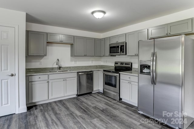 kitchen with gray cabinets, sink, appliances with stainless steel finishes, and dark hardwood / wood-style floors