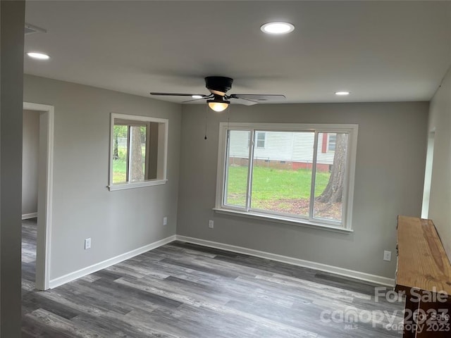 unfurnished room with dark hardwood / wood-style flooring, ceiling fan, and a wealth of natural light