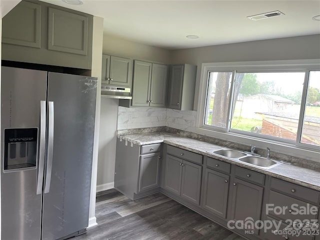 kitchen with backsplash, dark hardwood / wood-style floors, stainless steel refrigerator with ice dispenser, and sink