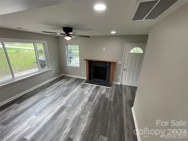 unfurnished living room featuring ceiling fan and dark hardwood / wood-style floors