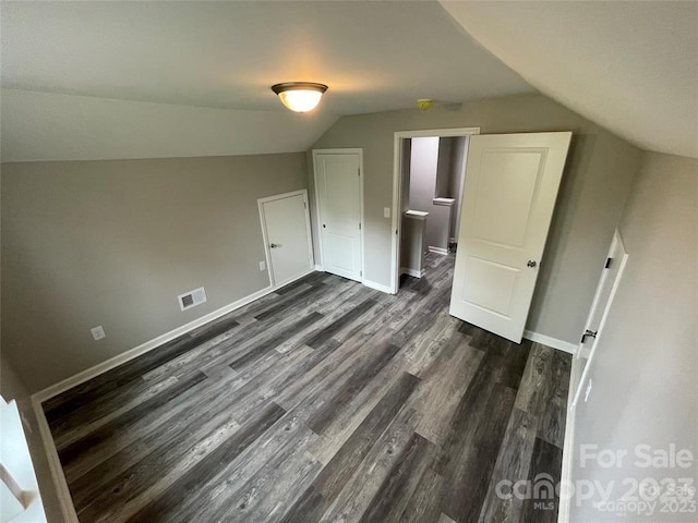 bonus room with dark wood-type flooring and lofted ceiling